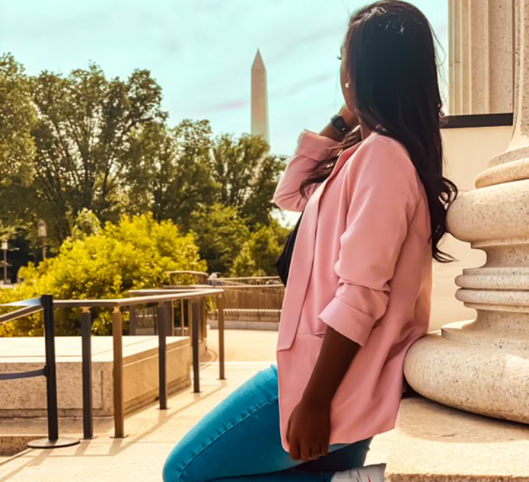 Woman in pink blazer near Washington Monument.