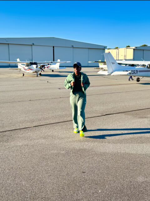Person walking on airfield near small planes.