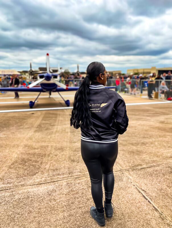 Person standing near airplane at airshow.
