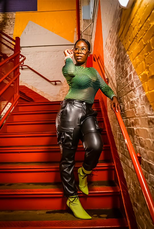 Person posing on vibrant red staircase.